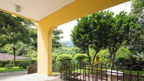 A covered outdoor area with a yellow wall, a metal fence, and a bench. - 2-bedroom apartment in charming Cuidad Colon with WiFi. (Cuidad Colon)