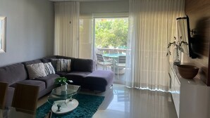 Ein modernes Wohnzimmer mit einer Couch, einem Couchtisch und einem Deckenventilator.