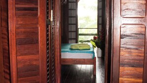 Une pièce en bois avec un lit, une fenêtre et une porte.