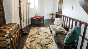 A rustic room with a wooden bench, a fur rug, and a wooden chest.