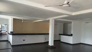A spacious, modern hotel lobby with dark tiled floors, white walls, and a reception desk. - Bluefin Hotel (Somanya)