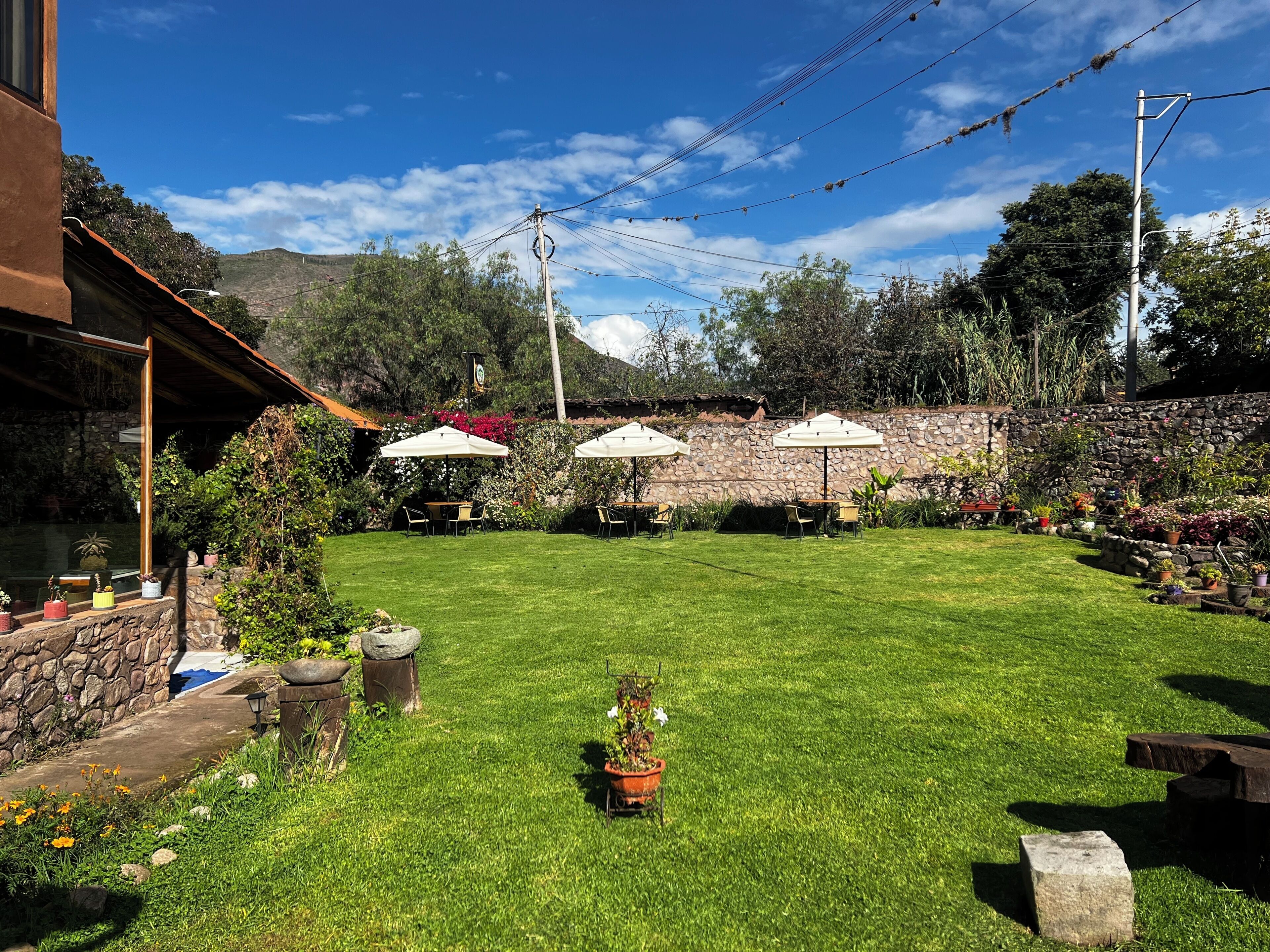 A well-maintained backyard with a stone wall, a grassy lawn, and outdoor furniture.