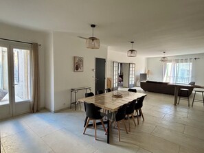 A spacious living area with a dining table, chairs, a sofa, and a balcony. - Fully renovated, air-conditioned 6-person apartment (Saint-Cannat)