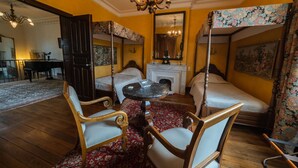 A room with a bed, a table, and two chairs. There is a mirror on the wall and a chandelier. - Château privé avec piscine à Cordes-sur-Ciel - Peace, nature and charm-Tarn (Cordes-sur-Ciel)