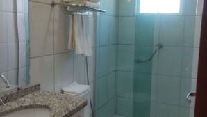 Une salle de bain avec des toilettes, un lavabo et une douche.