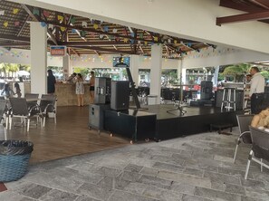 A covered outdoor area with tables and chairs, a stage, and a sign reading 'Brahma.' - Lacqua Di Roma via Roberto Imoveis (Caldas Novas)