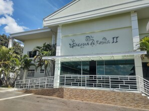 A building with a sign reading 'Acqua di Roma II' and a covered entrance with a glass facade. - Lacqua Di Roma via Roberto Imoveis (Caldas Novas)