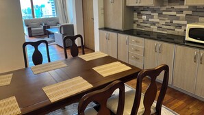 A modern kitchen with wooden cabinets and a black countertop. - Delightful 3-bedroom apartment with best view in Addis Ababa (Addis Ababa)