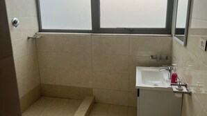 Une petite salle de bain avec une douche, un lavabo et une fenêtre.