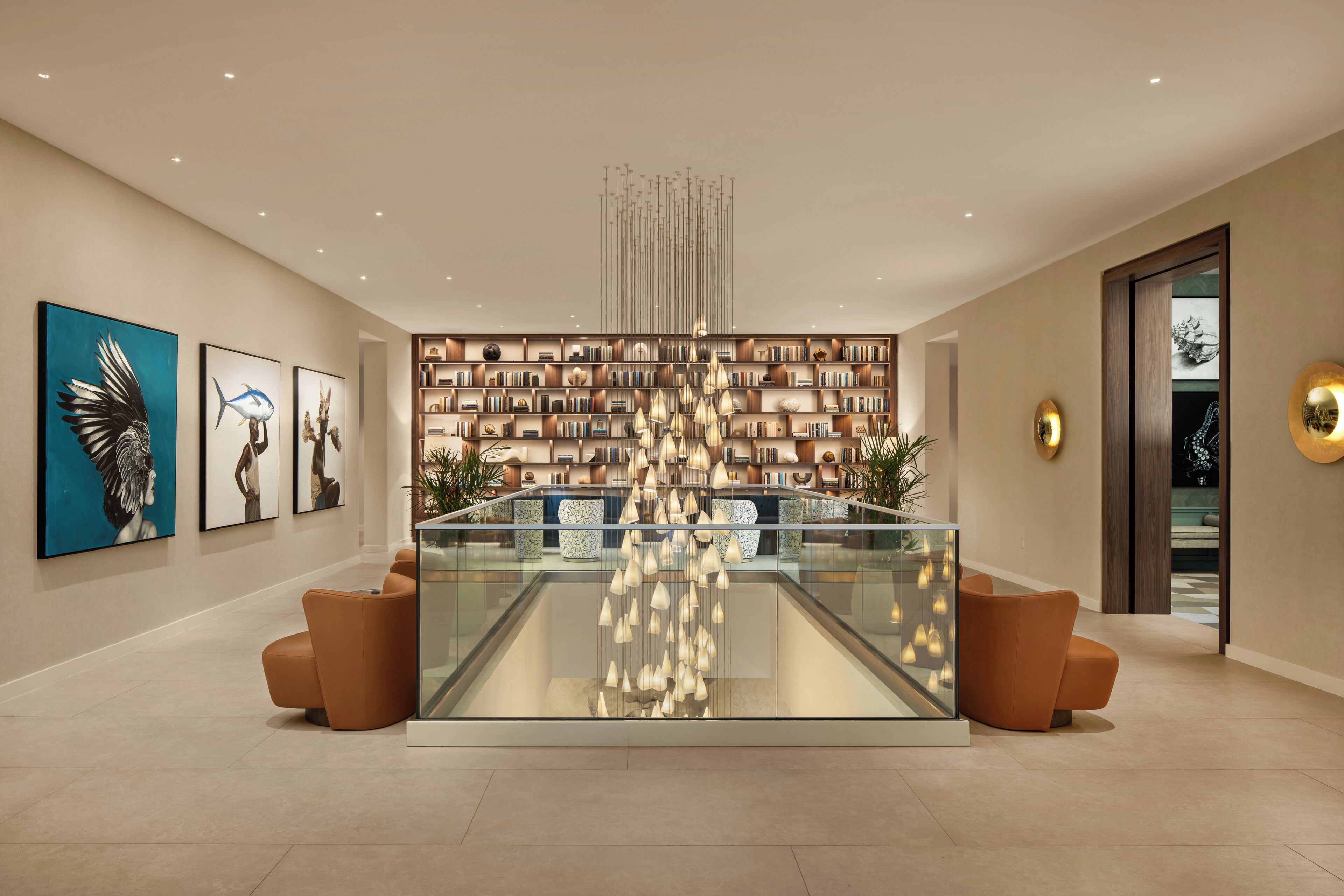A modern lobby with a glass display case, bookshelves, and artwork on the walls.