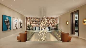 A modern lobby with a glass display case, bookshelves, and artwork on the walls.