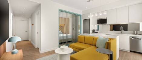 A modern apartment with a living area, kitchen, and a bedroom with a window.