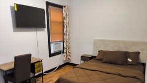 A bedroom with a bed, a desk, and a chair. - Spacious 4-bedroom, 4 beds 2 bath each, in lovely Newark with AC, WiFi. (Newark)