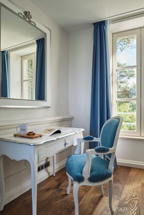 A room with a white vanity, a blue chair, and a large mirror. - Les Maisons De Tatihou, The Originals Relais (Saint-Vaast-la-Hougue)
