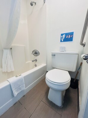 A bathroom with a bathtub, toilet, and a shower curtain. - Mountain View Inn Irvine Near Richmond KY (Irvine)