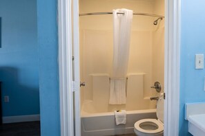A bathroom with a shower, toilet, and a towel rack.