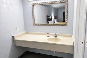 A bathroom with a white sink, a mirror with an ornate frame, and a towel rack. - Mountain View Inn Irvine Near Richmond KY (Irvine)