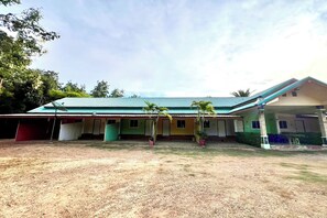 A two-story building with a green roof, multiple rooms, and a covered outdoor area with potted plants. - Chalalai Resort Kham Chanot By Zuzu (Ban Dung)