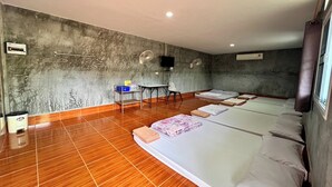 A hotel room with a large bed, a small desk, a chair, and a television on the wall. - Chalalai Resort Kham Chanot By Zuzu (Ban Dung)