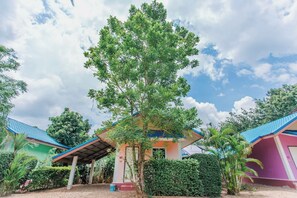 A building with a blue roof, surrounded by greenery and a clear sky. - Chalalai Resort Kham Chanot By Zuzu (Ban Dung)