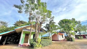 A row of single-story buildings with green roofs and a covered outdoor area.