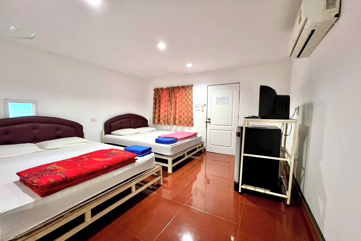 A room with two beds, a desk, and a TV.