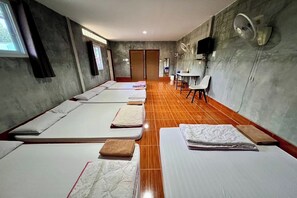 A room with four single beds, a small table, a chair, and a fan. - Chalalai Resort Kham Chanot By Zuzu (Ban Dung)