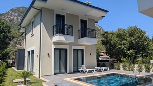 Et moderne hus i to etager med swimmingpool, altaner og have.