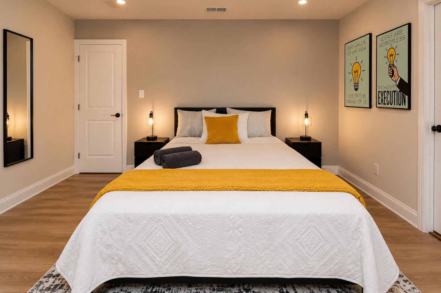 A bedroom with a bed, two bedside tables, a door, and two wall art pieces.