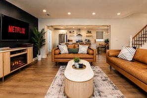 Una sala moderna con chimenea, televisor y comedor.
