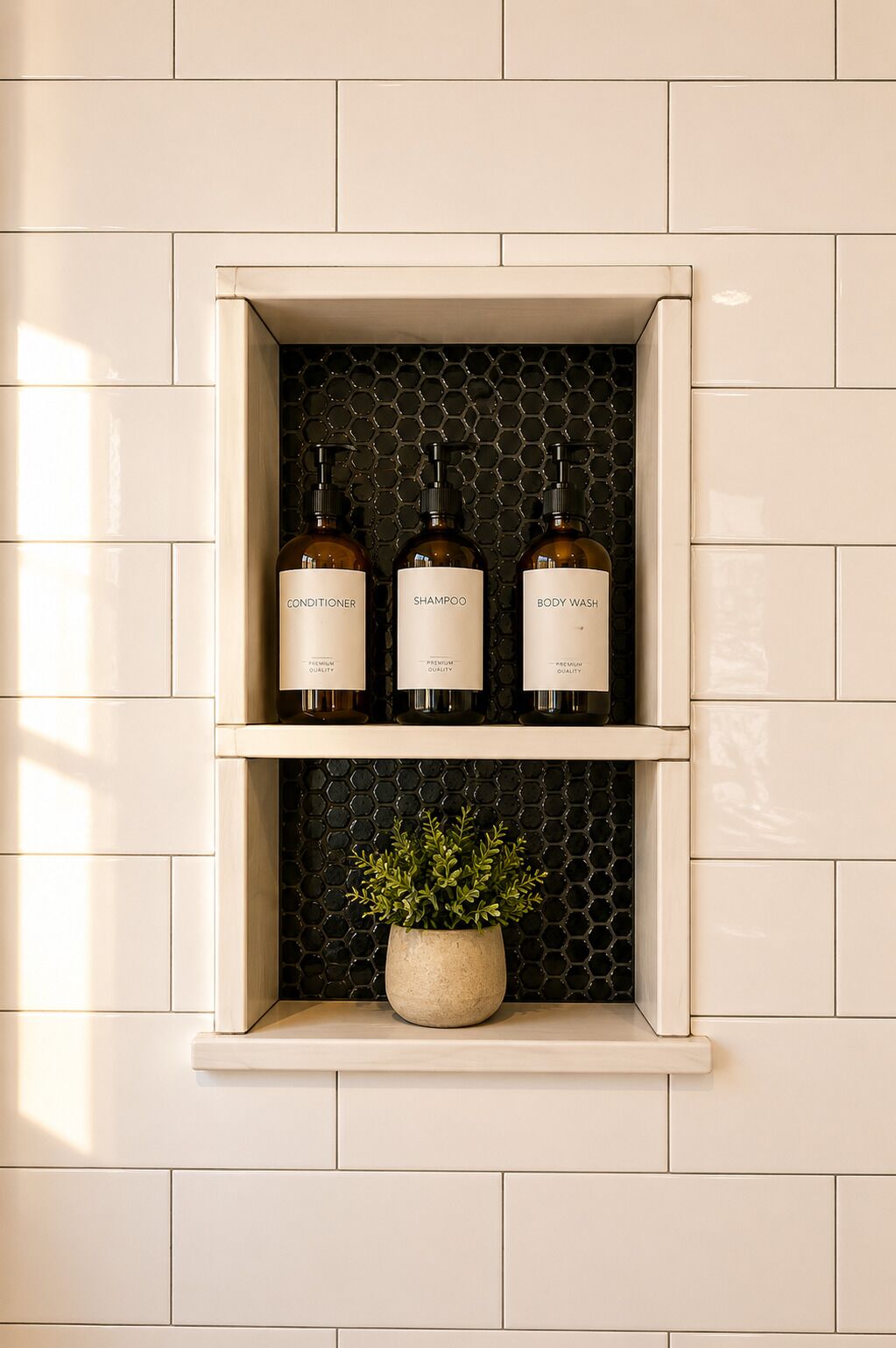 Ein Regal mit drei Flaschen, beschriftet mit 'Conditioner', 'Shampoo' und 'Body Wash', vor einer Wand mit sechseckigen Fliesen.