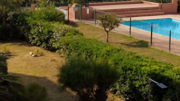 Una piscina rodeada de vegetación, con vistas a montañas distantes.