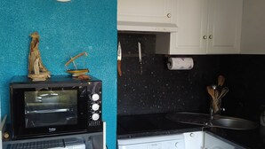 Una cocina con microondas, un reloj y armarios.