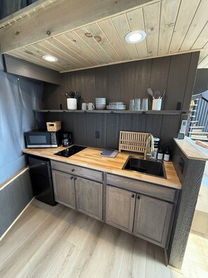 Een koelkast, kookgerei, borden en bestek