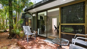Una casa moderna con un patio que cuenta con un ventanal de vidrio que da a una cocina y zona de comedor.