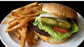 Una hamburguesa acompañada de papas fritas sobre un plato blanco.