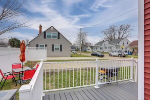 A residential deck with a white railing, a red and black outdoor table, and a gray house in the background. - 1 Block to Beach: Home w/ Hot Tub in Port Clinton! (Port Clinton)