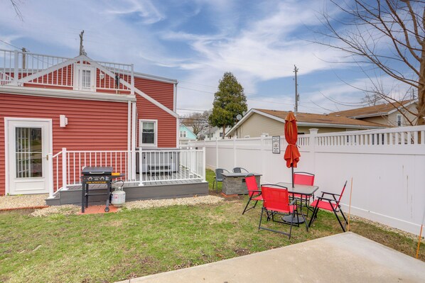 A backyard with a barbecue grill, outdoor seating, and a white fence. - 1 Block to Beach: Home w/ Hot Tub in Port Clinton! (Port Clinton)
