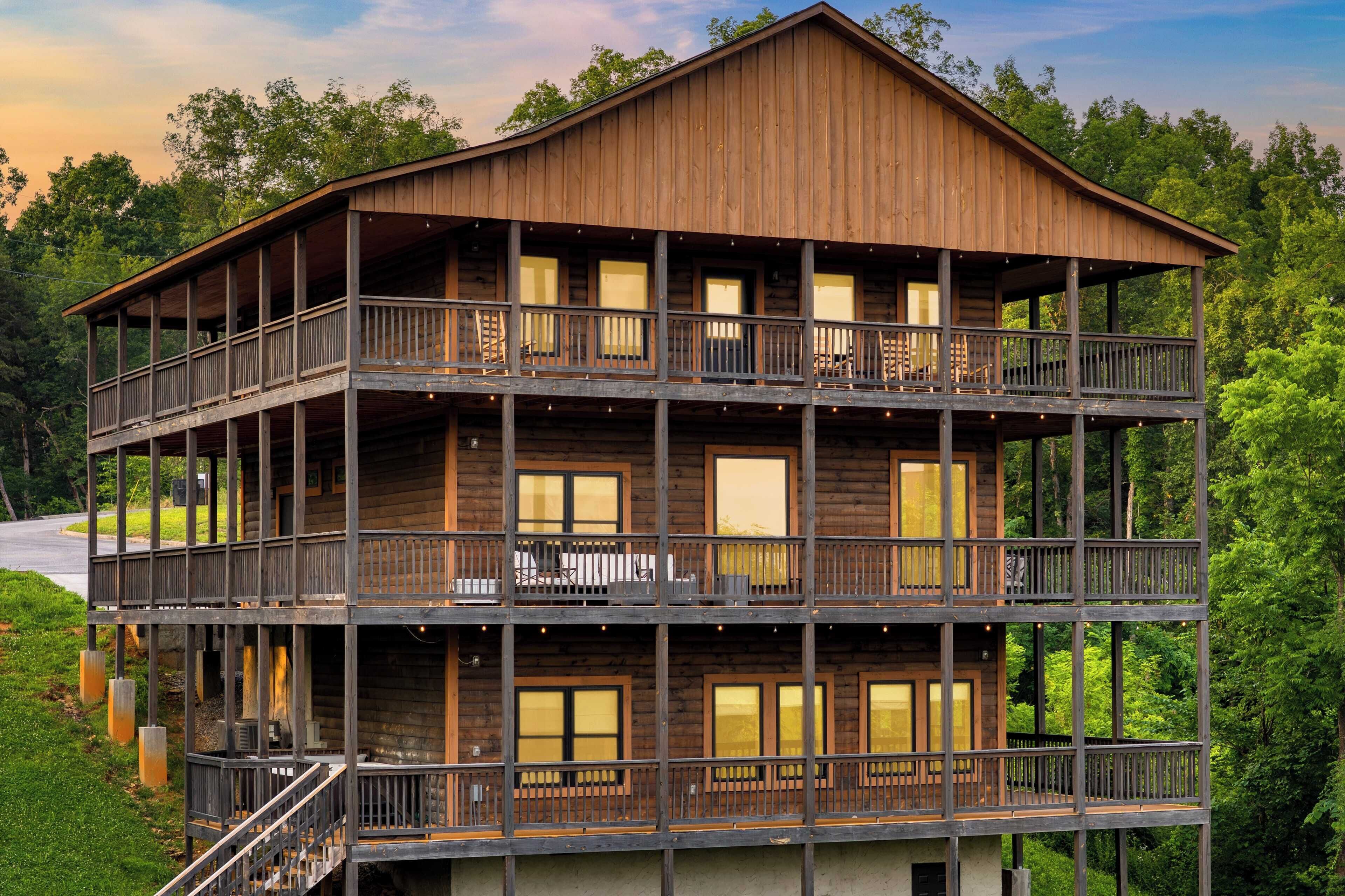A multi-story log cabin with balconies, large windows, and a wooden exterior.