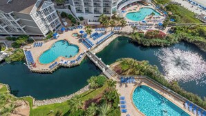 A resort with multiple swimming pools, a beach area, and a large hotel building.