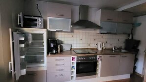 A compact kitchen with a microwave, toaster, oven, and a sink. - Leiningerland, the gateway to the Palatinate Enjoy with all your senses/ Pets welcome (Obersülzen)