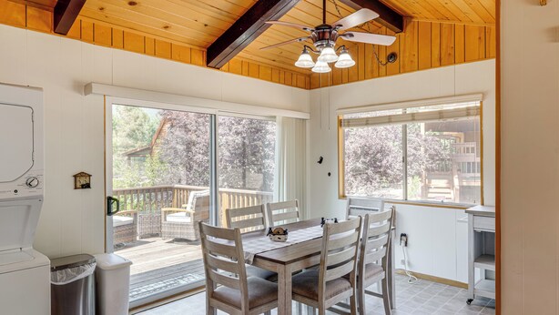 A kitchen with a wooden ceiling, large windows, and a dining table with chairs. - Mountain-View Haven w/ Deck in Pine Mountain Club (Frazier Park)