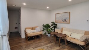 Un salon avec deux canapés, une table basse et un tableau accroché au mur.