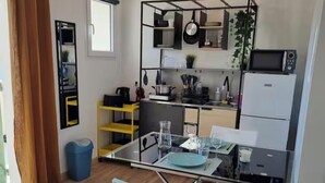 Una cucina funzionale con zona pranzo, forno a microonde e un appendiabiti per pentole.