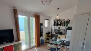 Un appartamento moderno con soggiorno, zona pranzo e cucina.