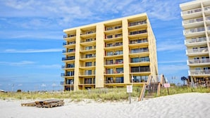 Un hotel de varios pisos con balcones, situado cerca de una playa.