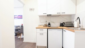 A modern kitchen with white cabinets, a dishwasher, and a coffee maker. - Modern Rooms Exarchia Room 2 (Athina)