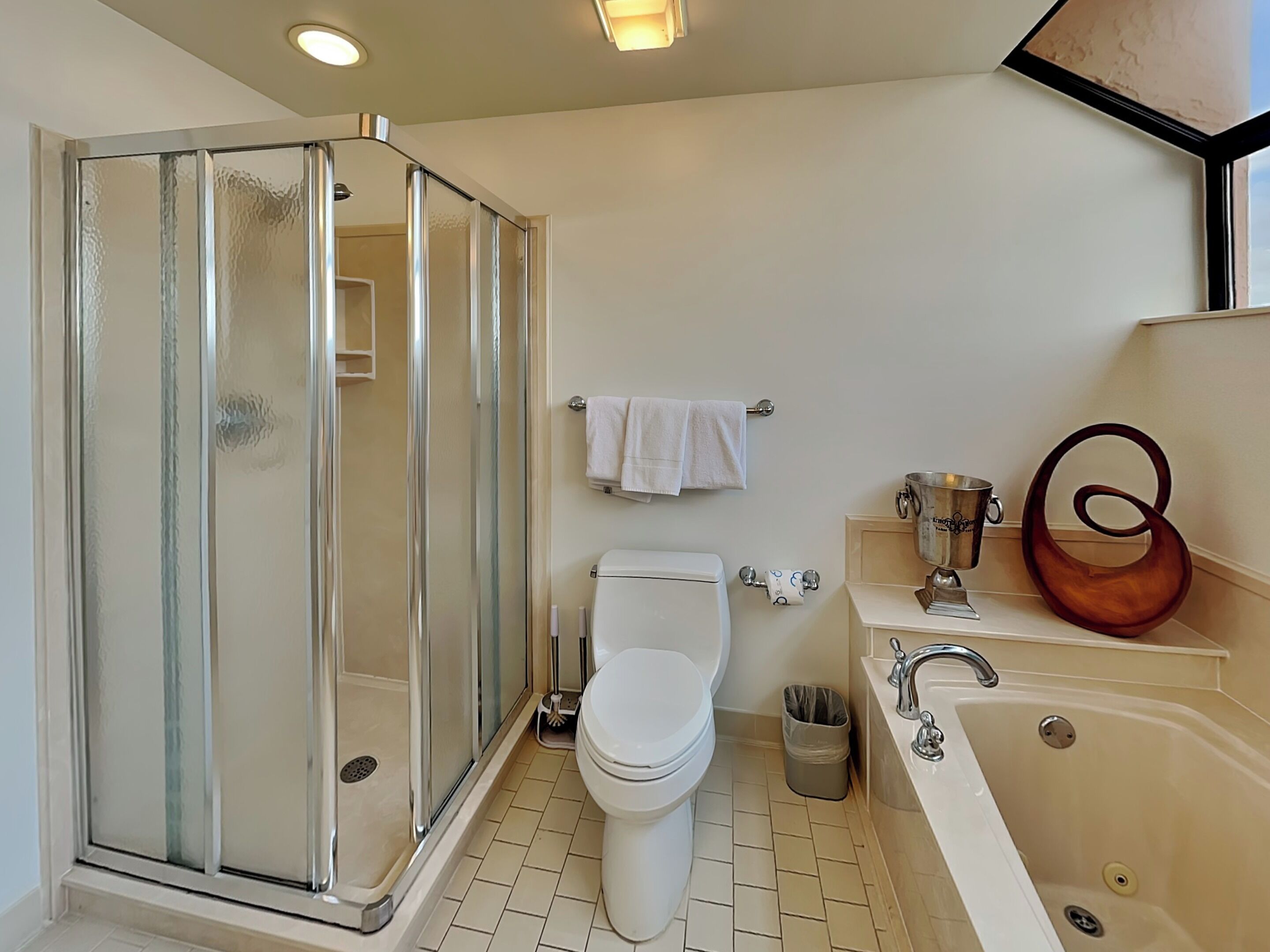 A bathroom with a glass-enclosed shower, a toilet, a sink, and a bathtub.