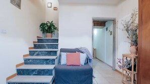 Eine Treppe mit Marmorstufen, ein Bett mit Kissen, ein Blumentopf und eine hölzerne Bank mit einer Vase.