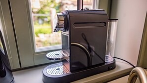 A coffee machine on a counter near a window. - Stylish accommodation in a monument in the heart of Halberstadt's old town (Halberstadt)